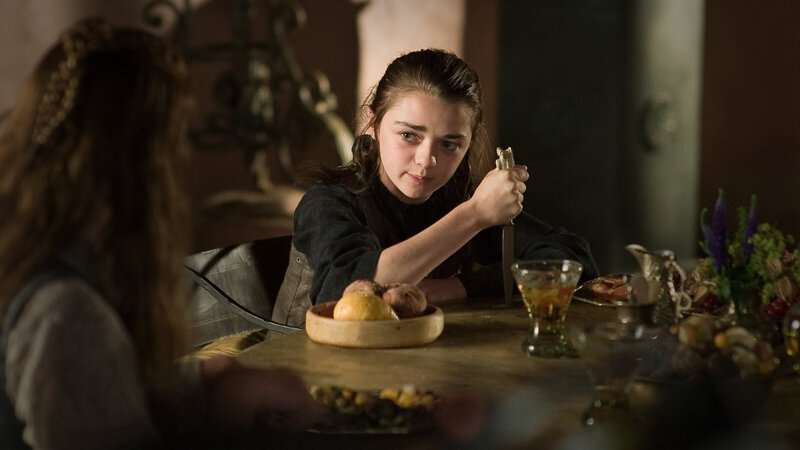 A girl holds a knife at dinner