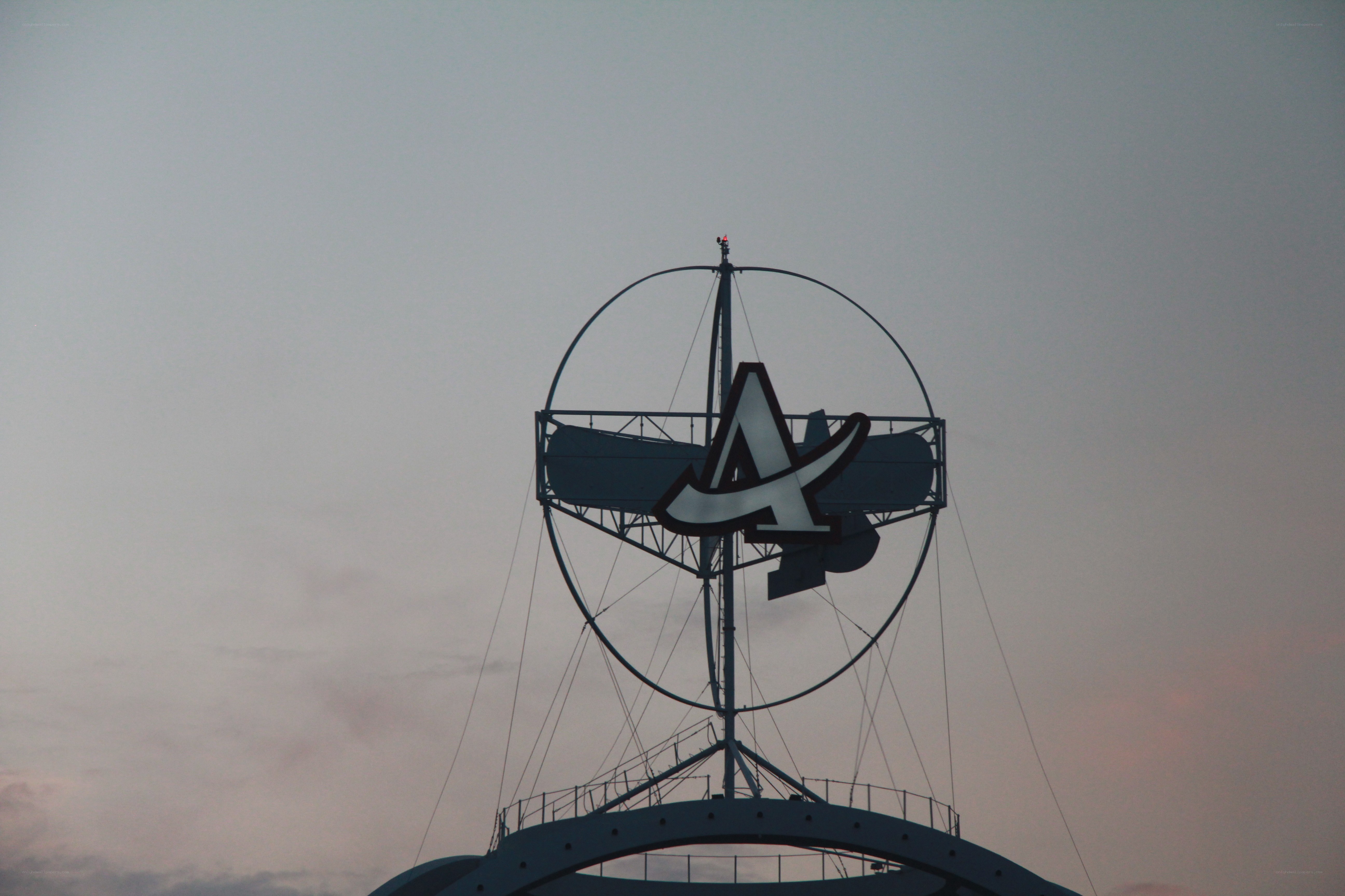 A logo on a tower at dusk