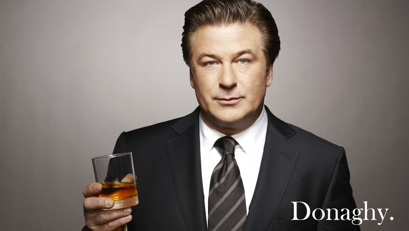 A man in a suit holding whiskey