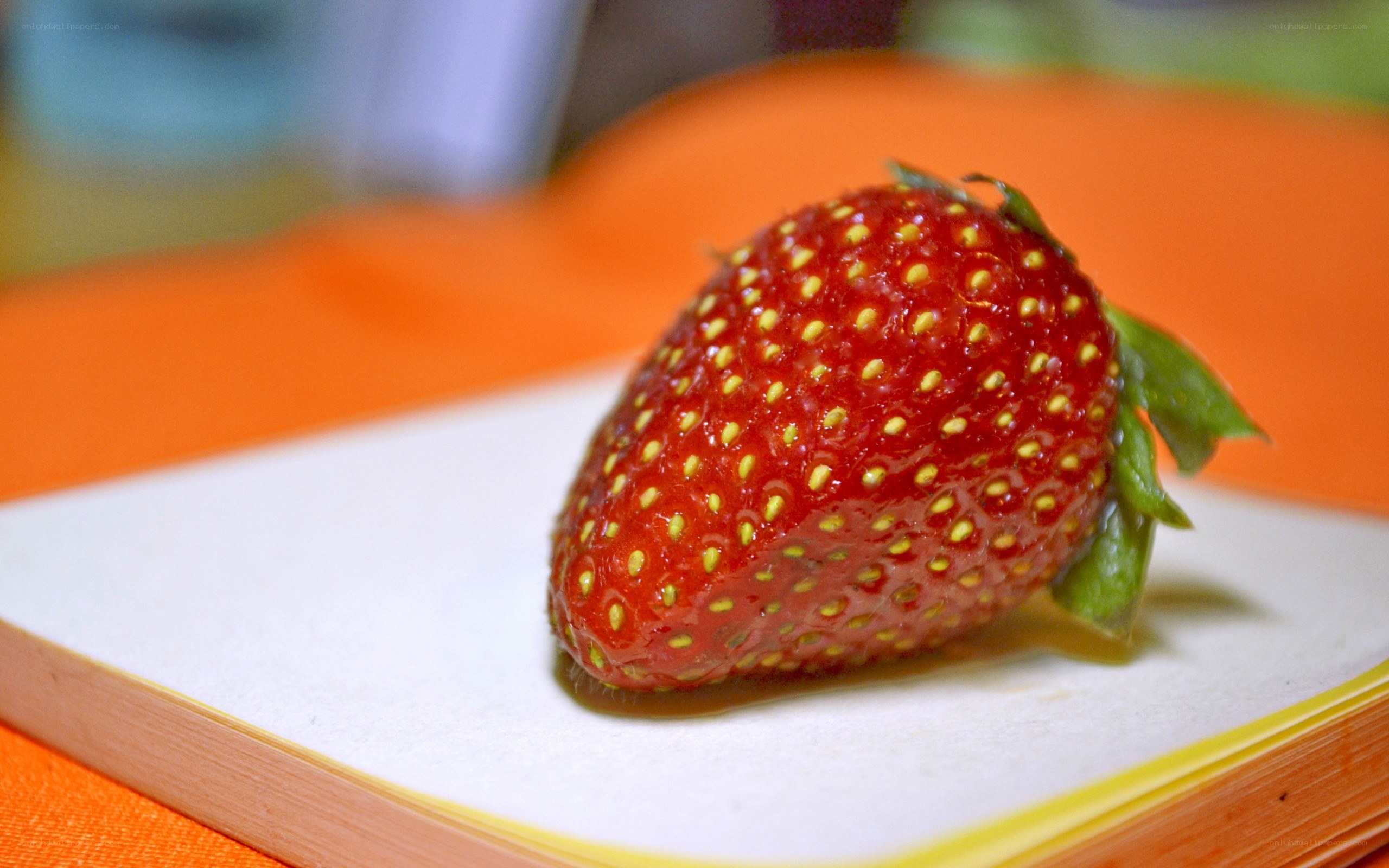 a single strawberry on a plate