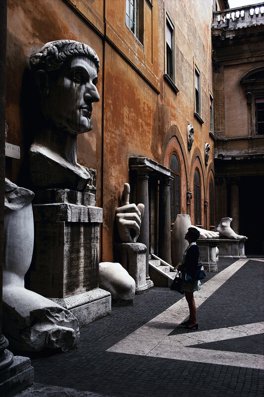A woman in a courtyard with ancient statues