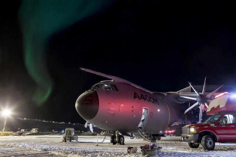 A400M aircraft at night with aurora