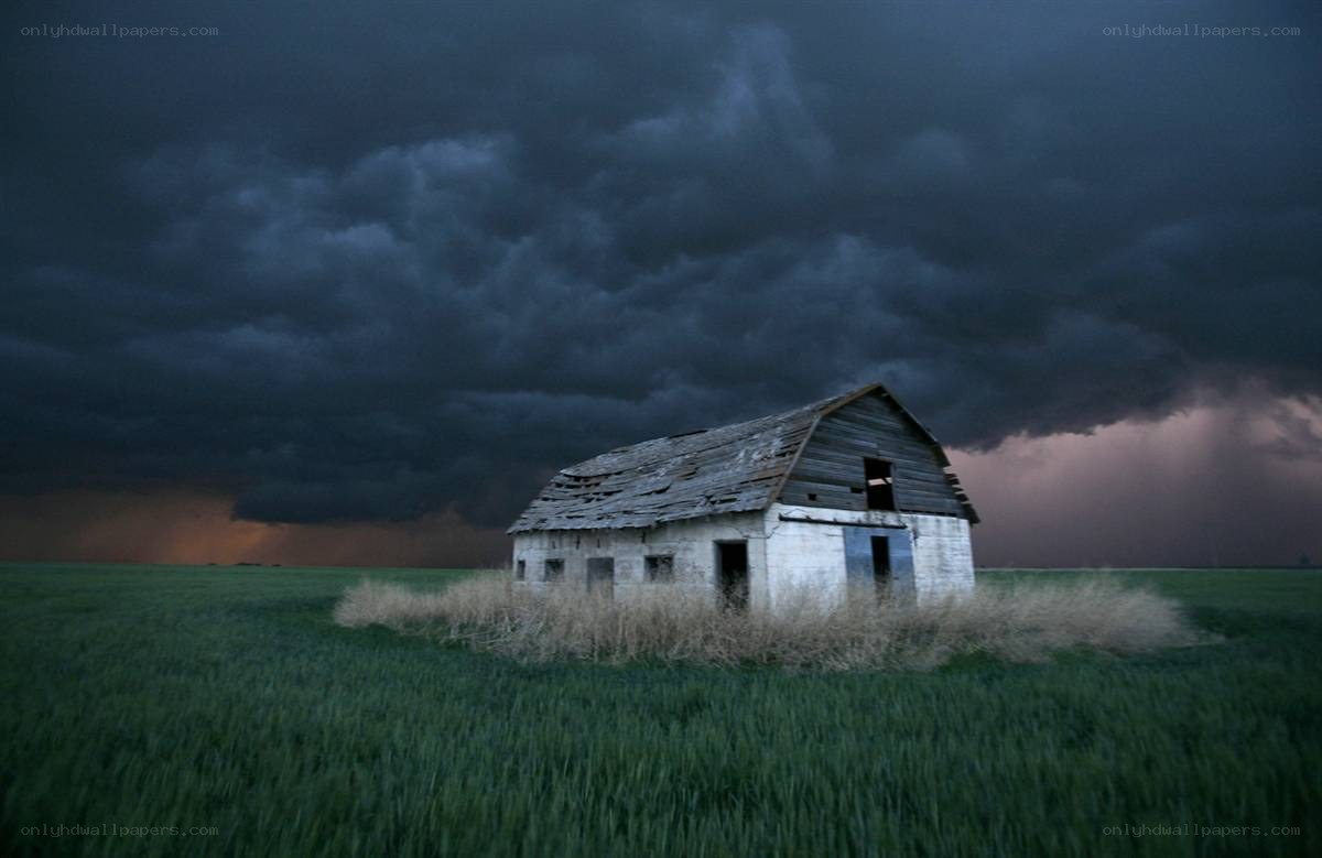 Abandoned barn under stormy sky