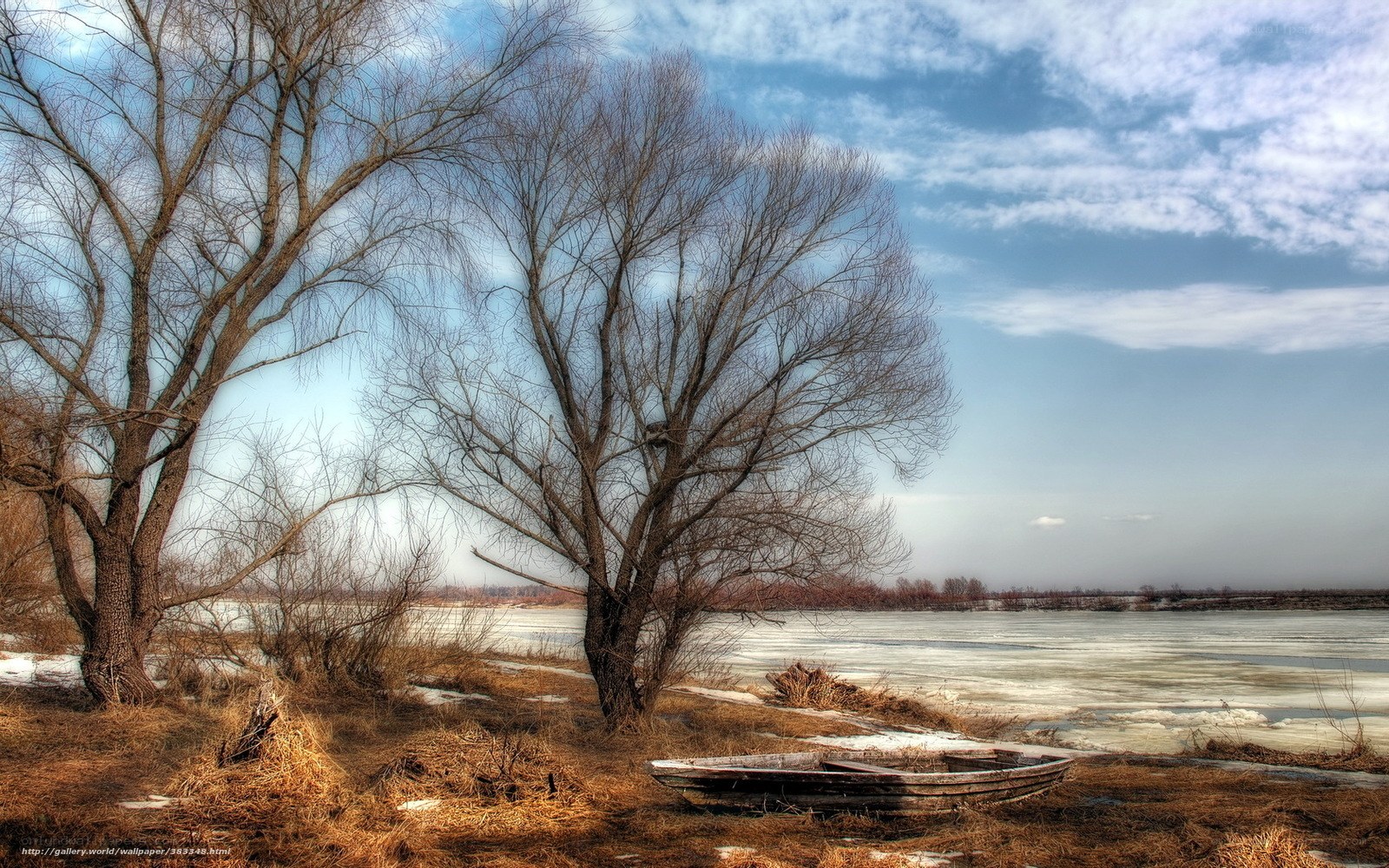 Abandoned boat by frozen river