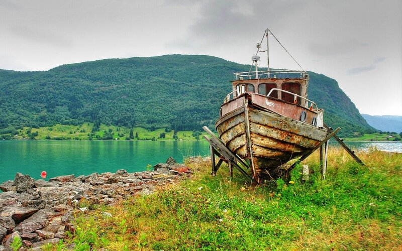 Abandoned boat on a fjord shore