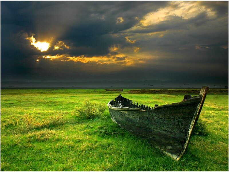 Abandoned boat on a grassy field