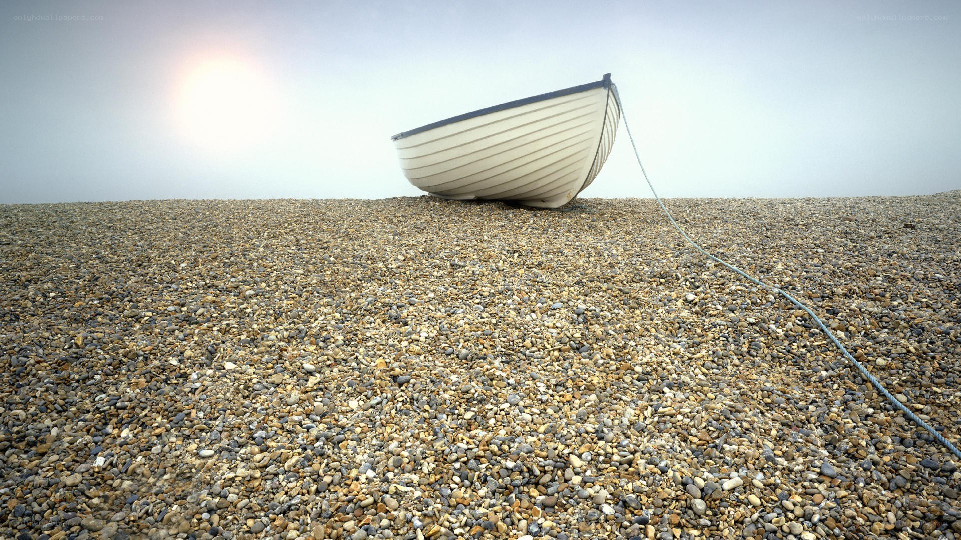 Abandoned boat on pebble beach