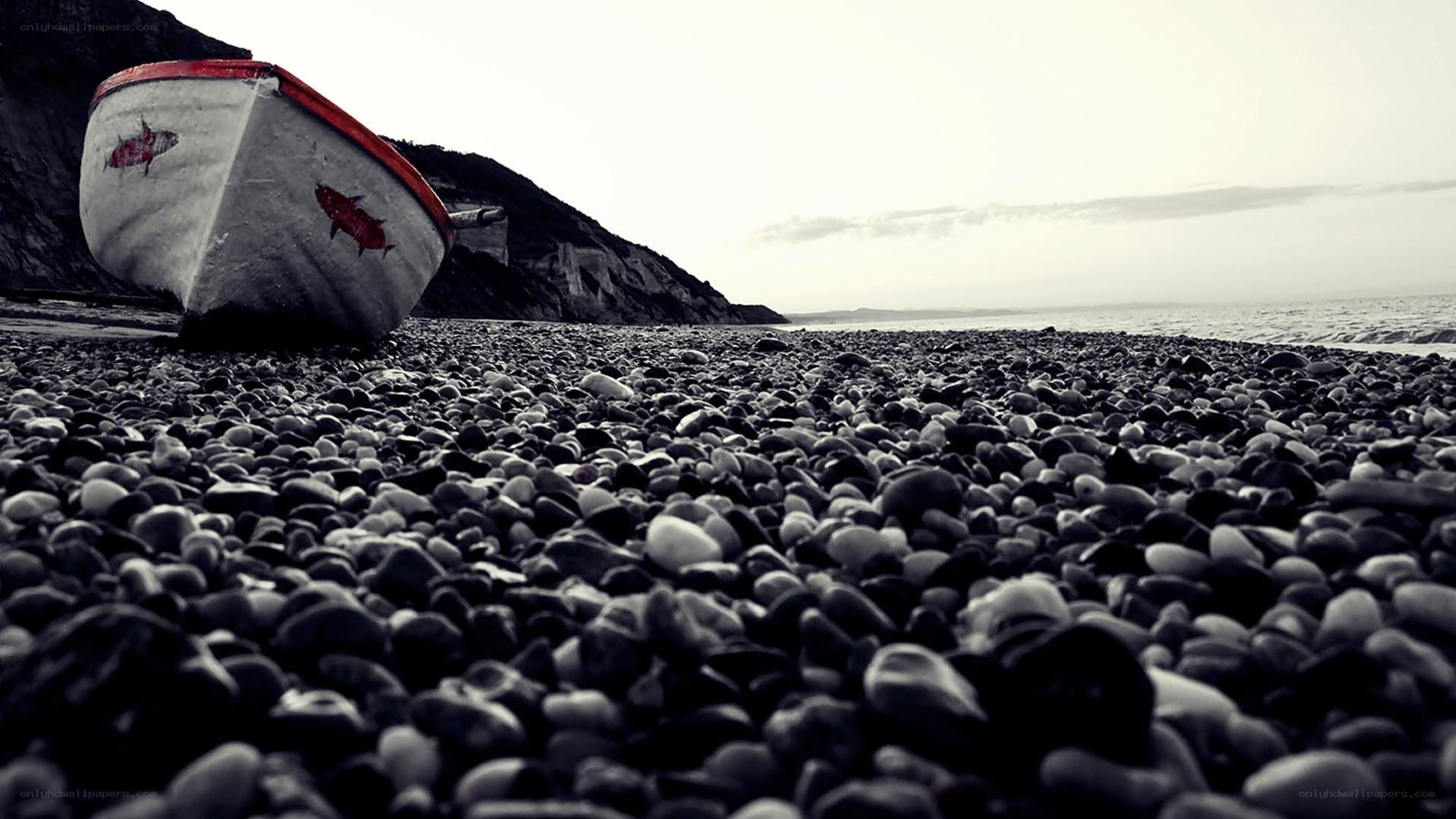 abandoned boat on pebble beach