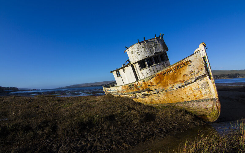 Abandoned Boat on Shore — Blue, Dramatic, Afternoon