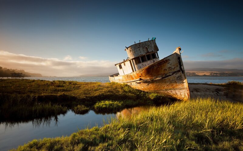 Abandoned Boat on Shore — Green, Serene, Sunset