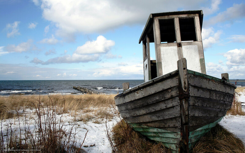 abandoned boat on snowy shore