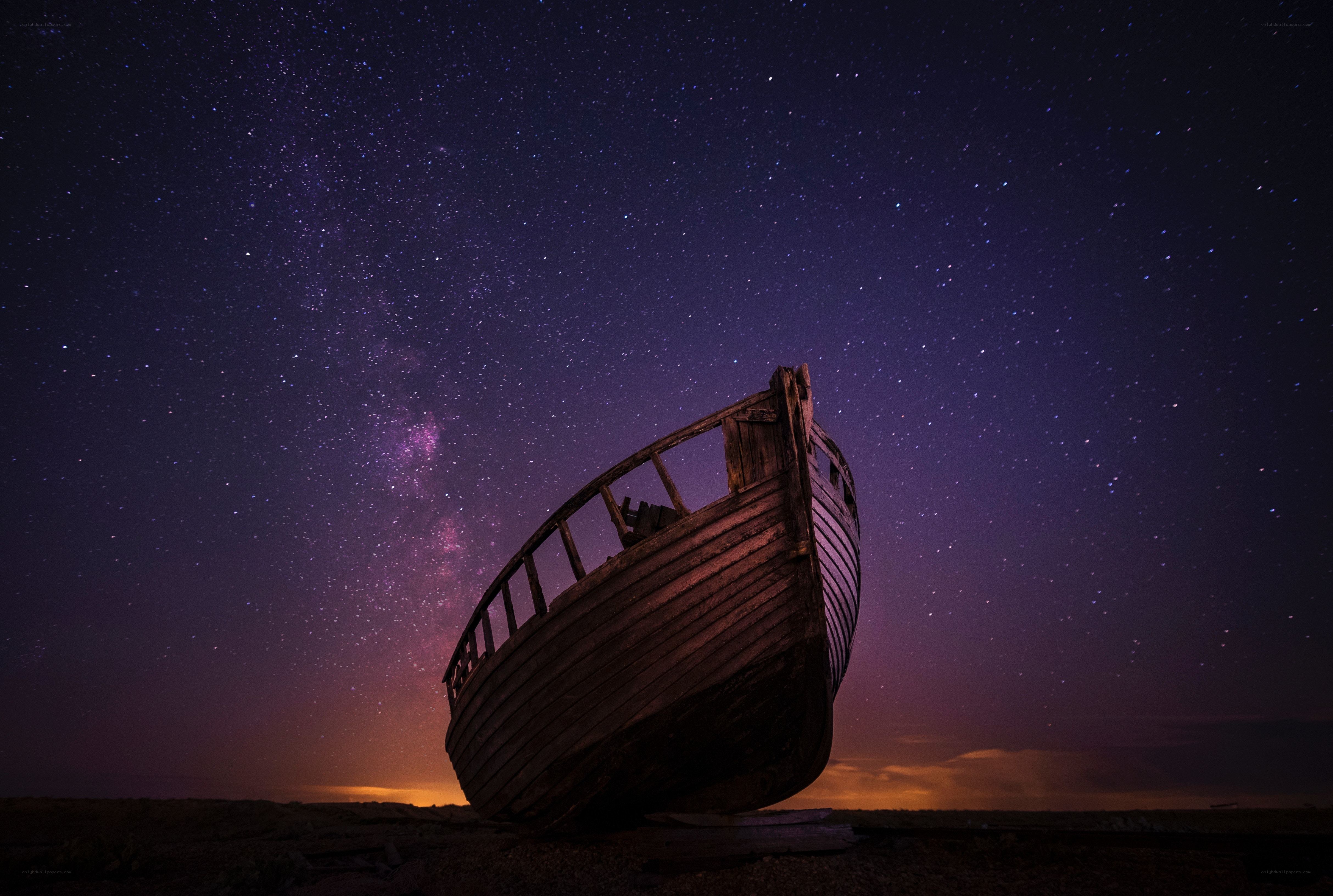 Abandoned boat under starry sky