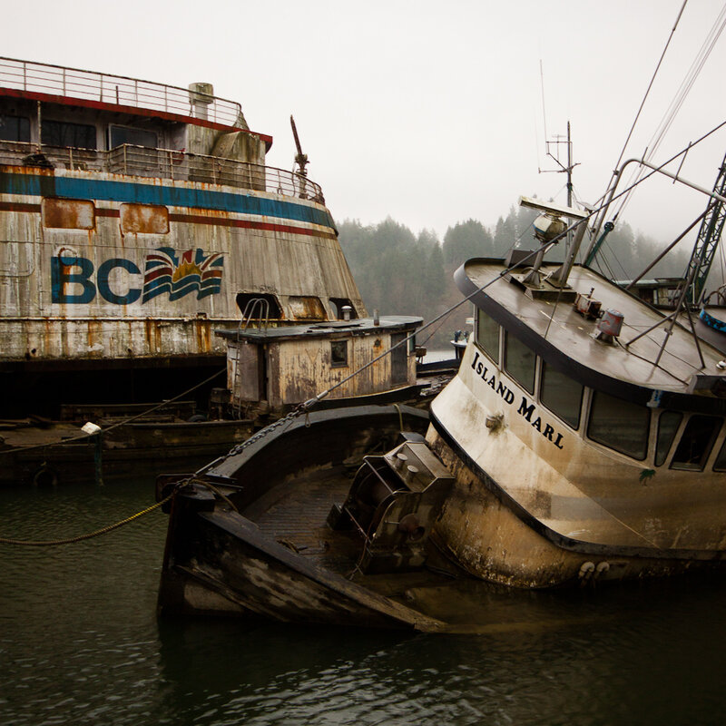 Abandoned boats in a foggy harbor