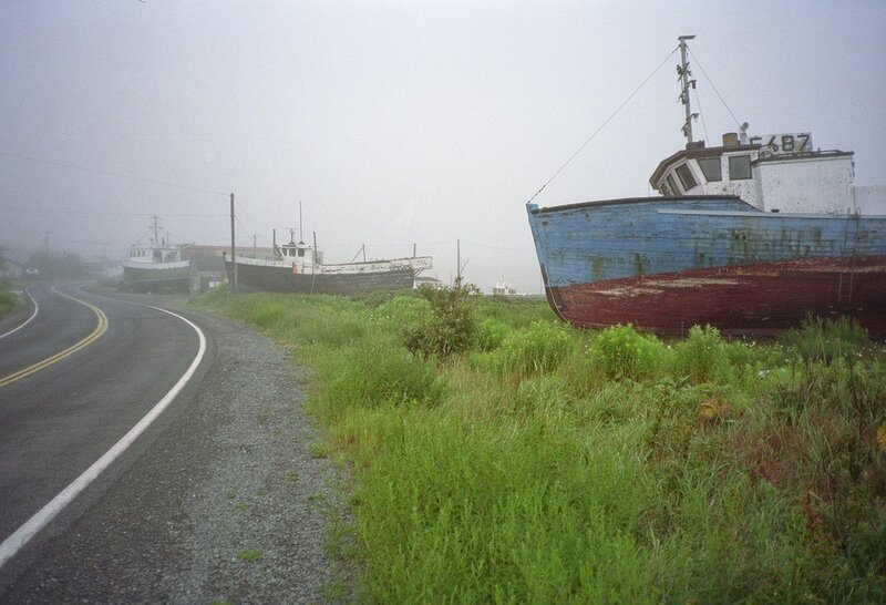 Abandoned boats on a foggy road