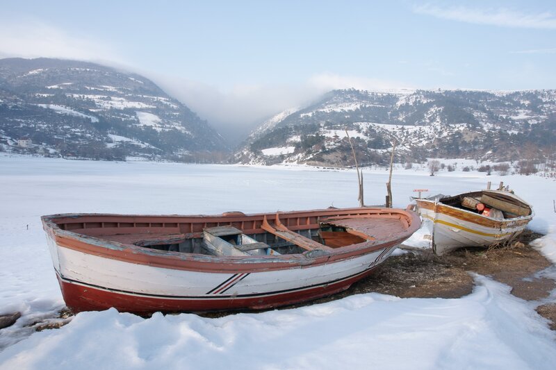 Abandoned boats on frozen lake