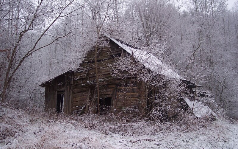Abandoned cabin in snowy woods