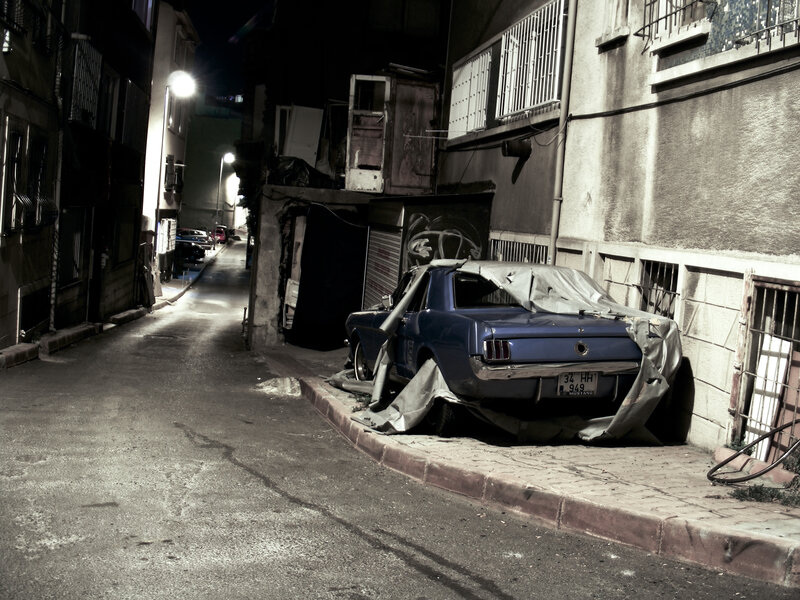 Abandoned car in alley at night