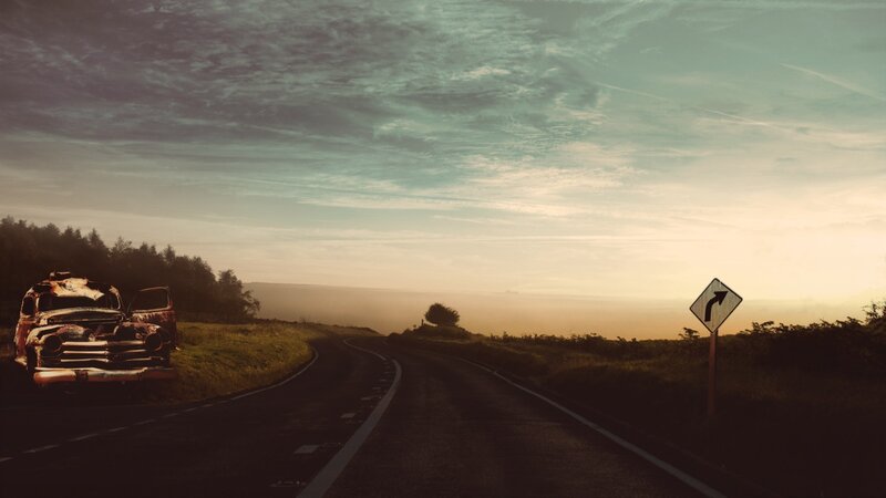 Abandoned car on a winding road