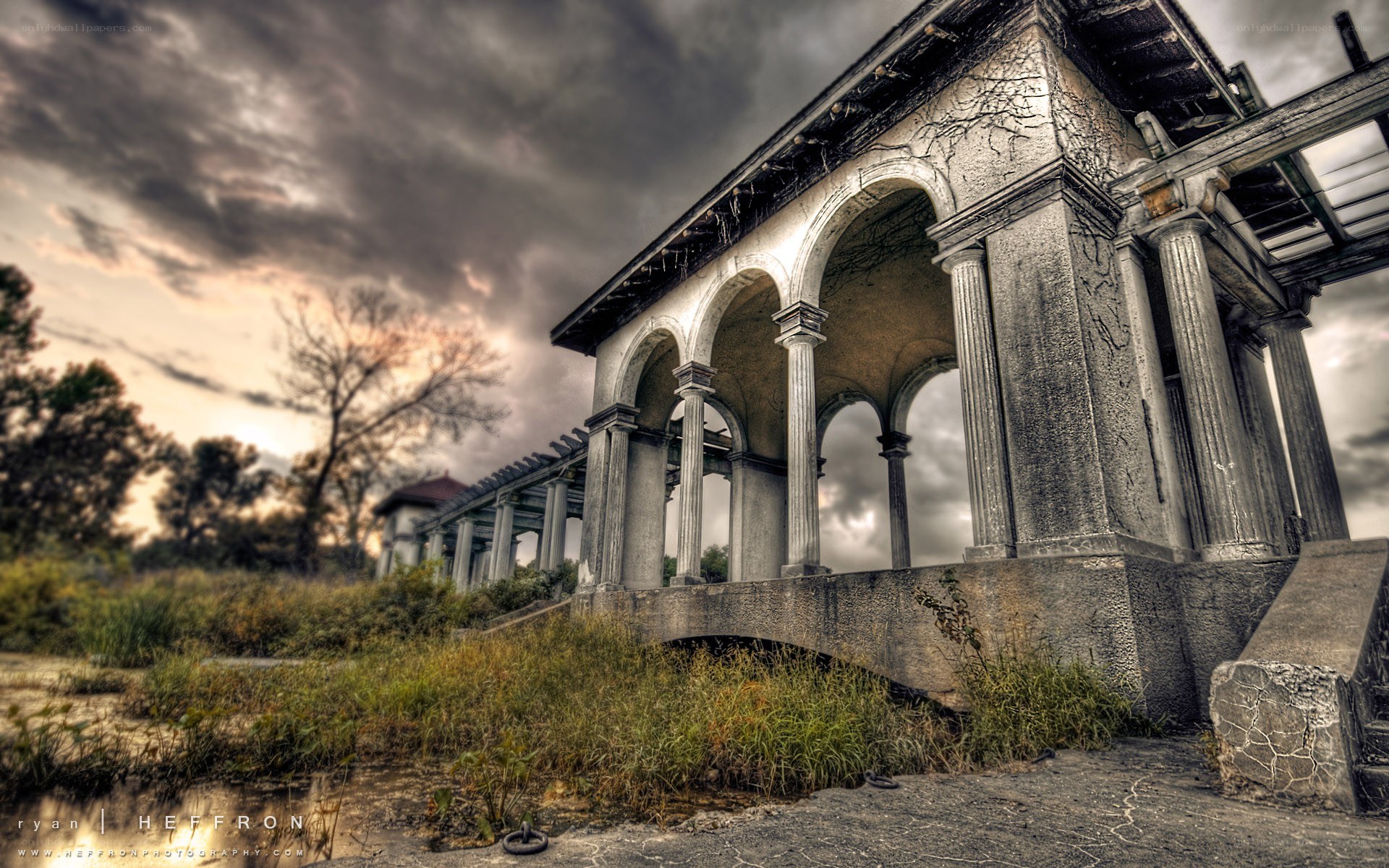 Abandoned colonnade under stormy sky