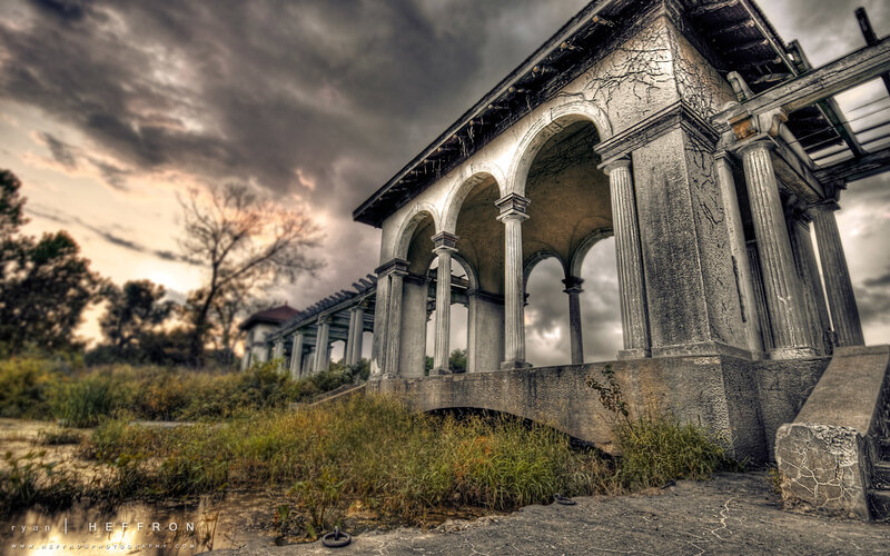 Abandoned colonnade under stormy sky