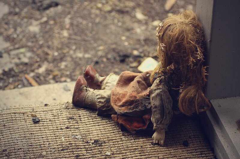 Abandoned doll on doorstep
