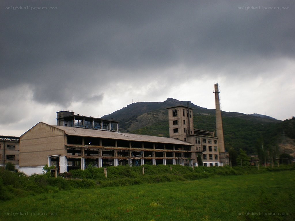 Abandoned factory with mountain backdrop