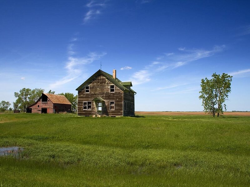 Abandoned farmhouse in a green field