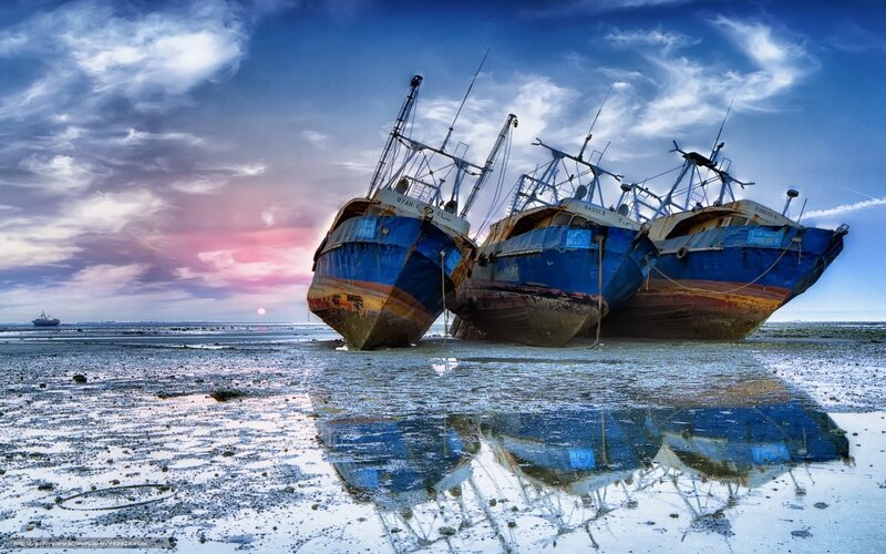 Abandoned fishing boats at sunset