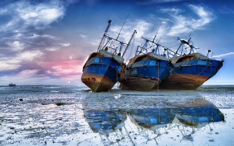 Abandoned fishing boats at sunset