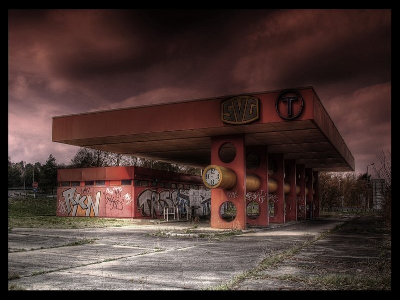 Abandoned gas station under stormy sky