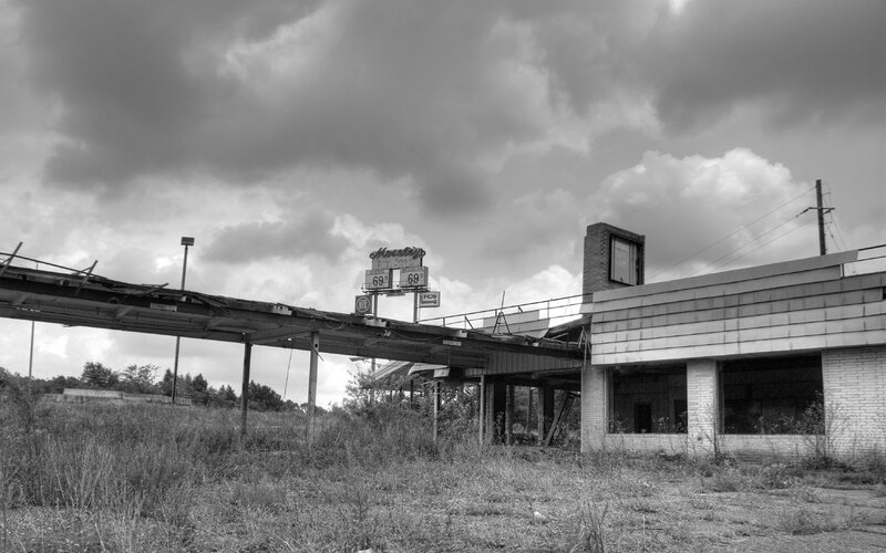 Abandoned gas station under stormy sky