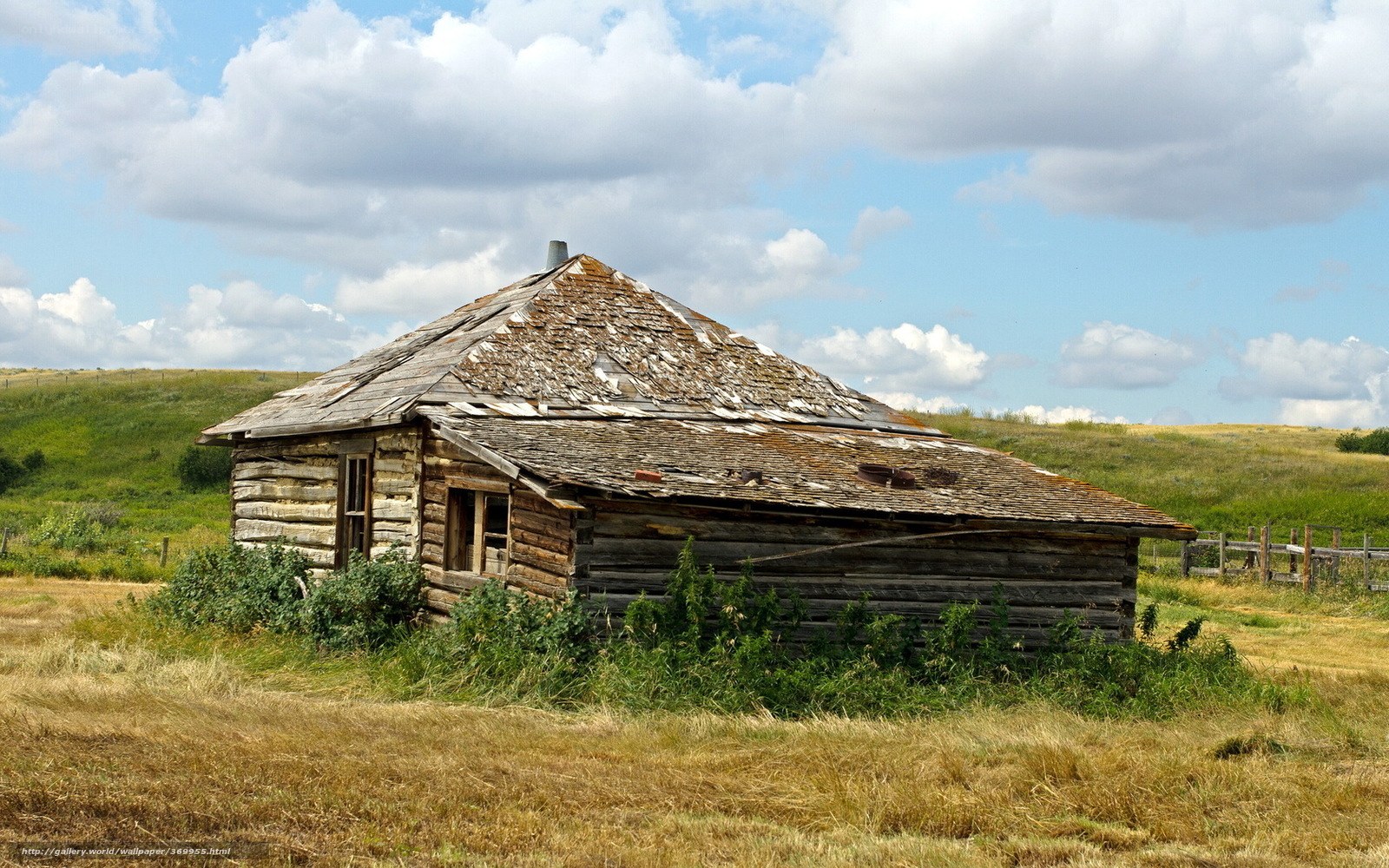 Abandoned log cabin in field