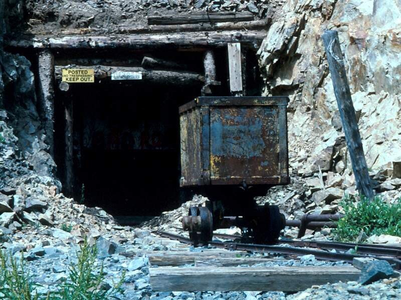 abandoned mine entrance with cart