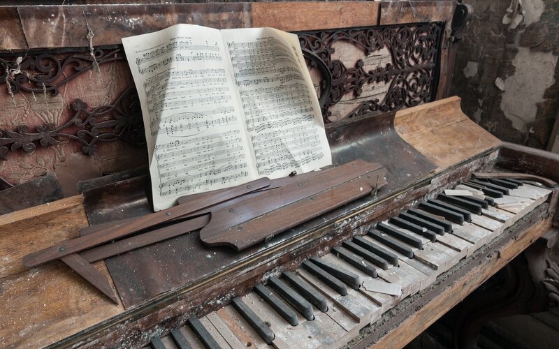 abandoned piano with sheet music