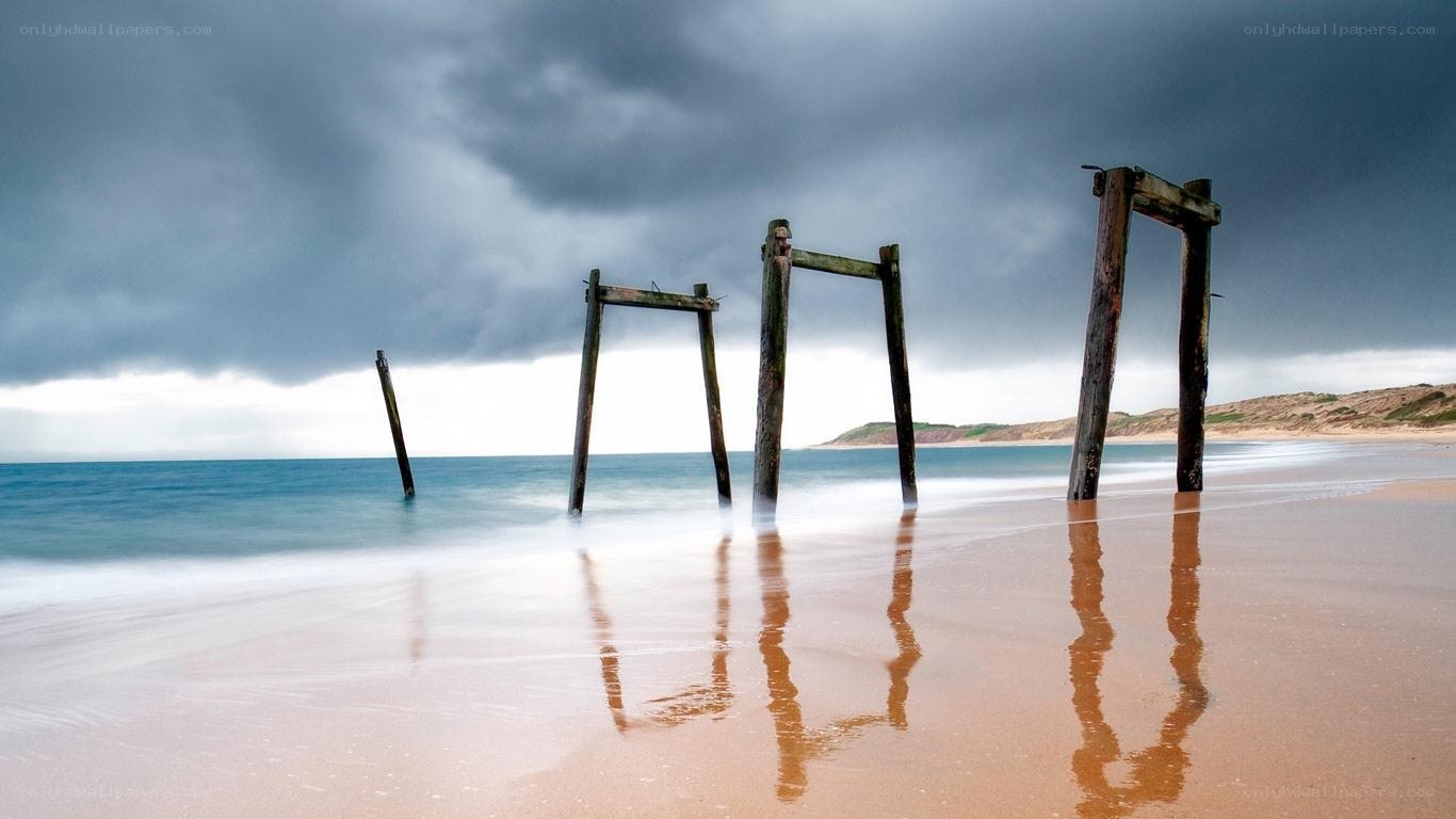 Abandoned pier on a stormy beach