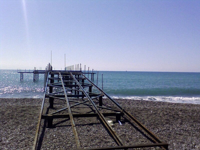 Abandoned pier on pebble beach