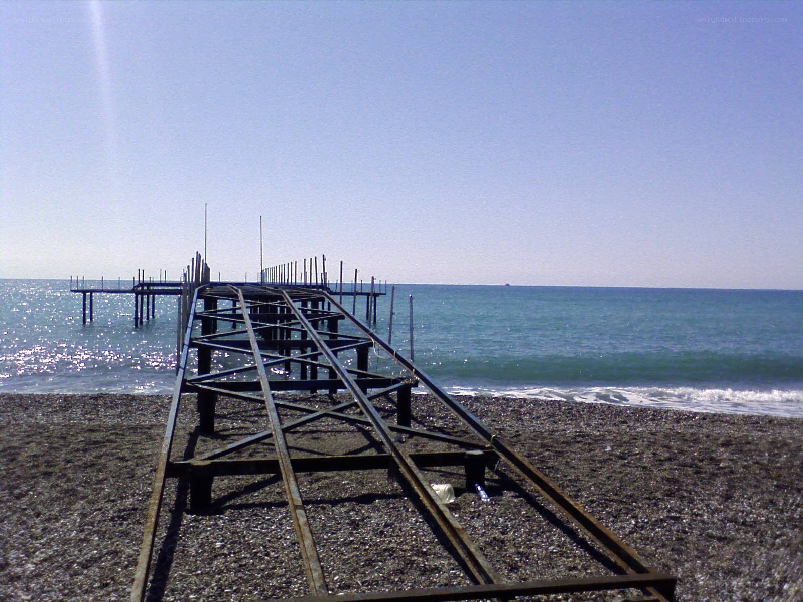 Abandoned pier on pebble beach