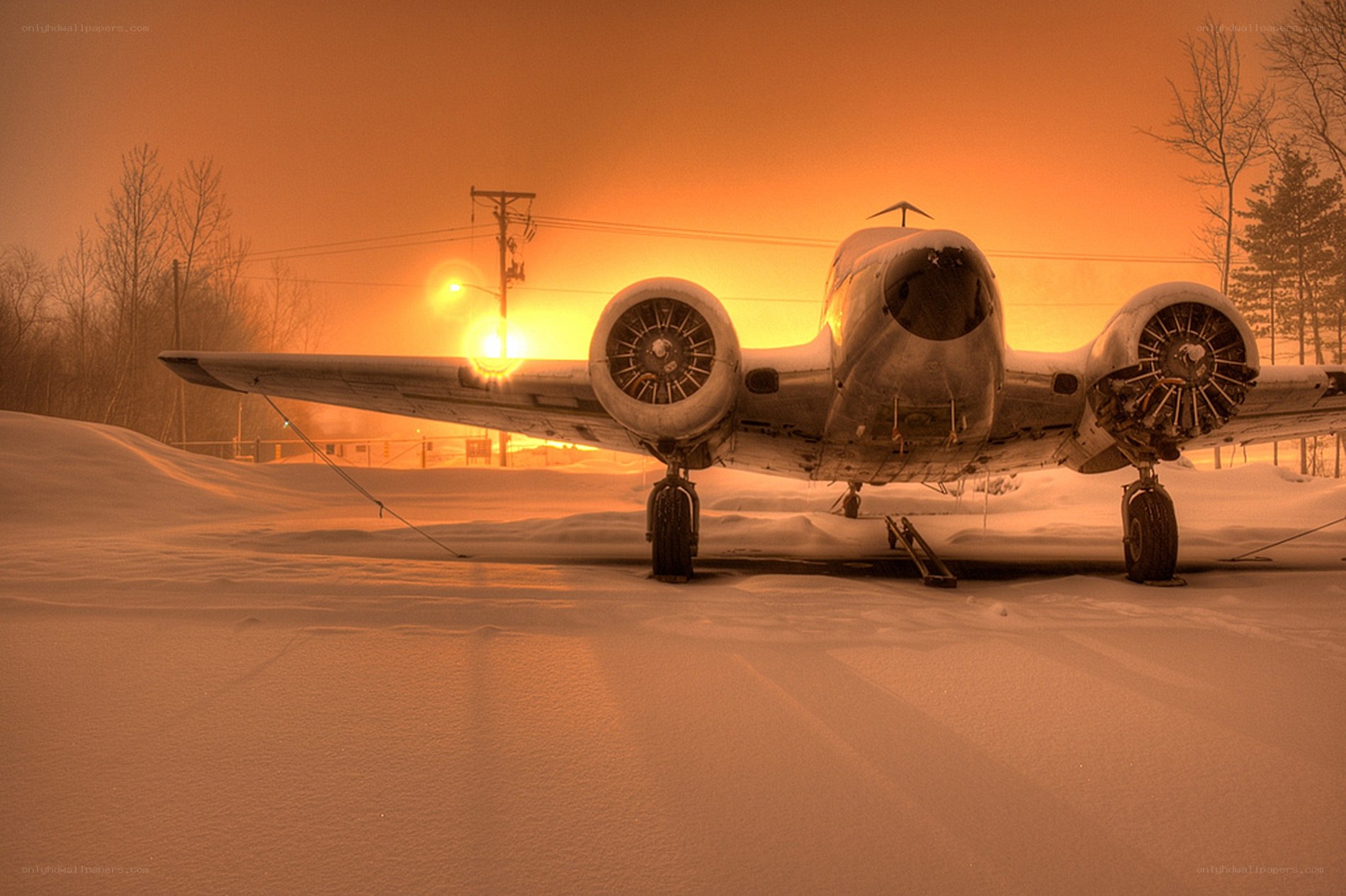 Abandoned plane in snow at sunset