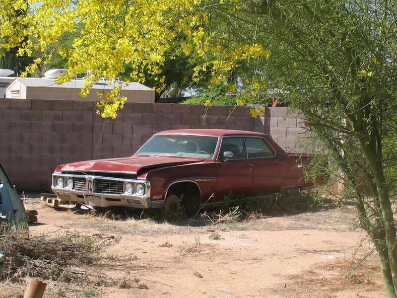 abandoned red car in yard