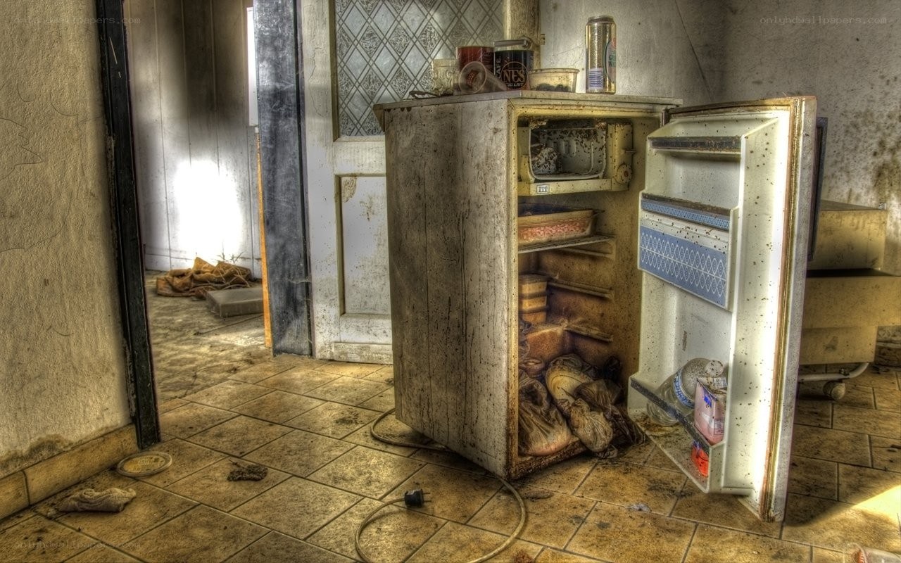 abandoned refrigerator in a derelict kitchen
