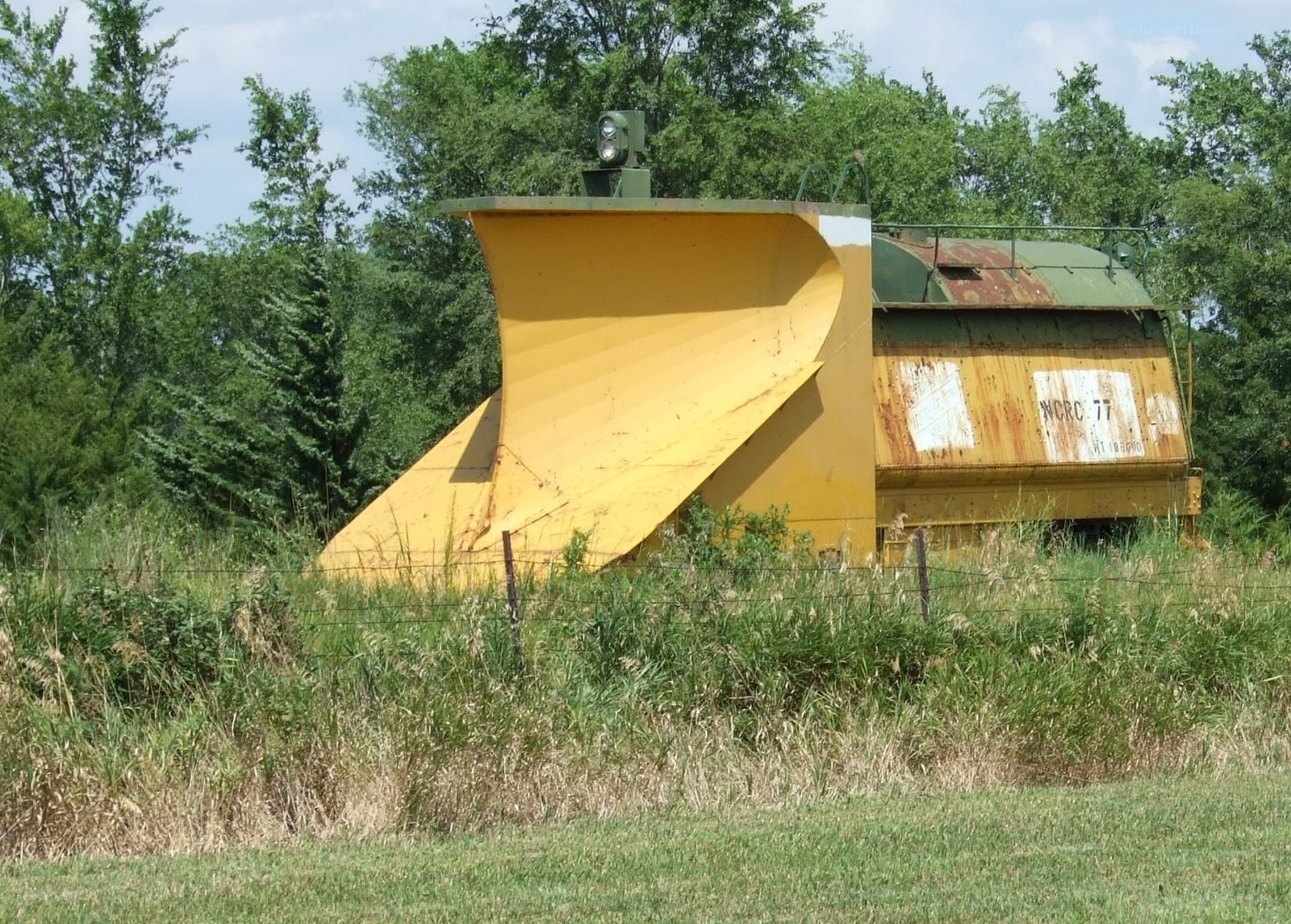 abandoned snowplow in field