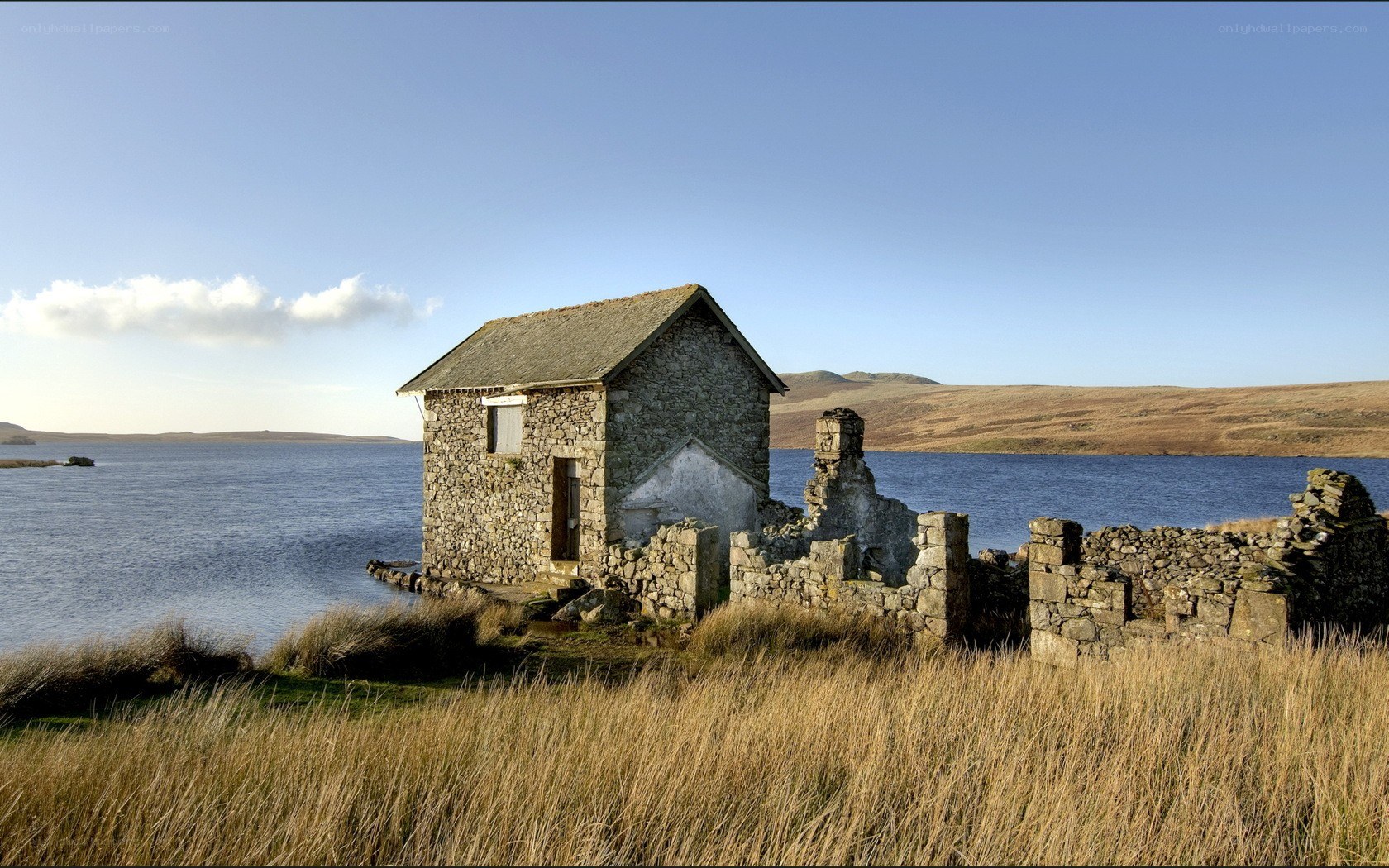 Abandoned stone building by a lake