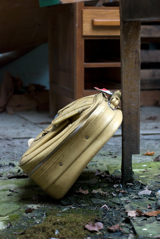 Abandoned suitcase in a derelict room