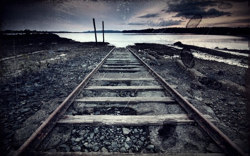 abandoned train tracks by the water