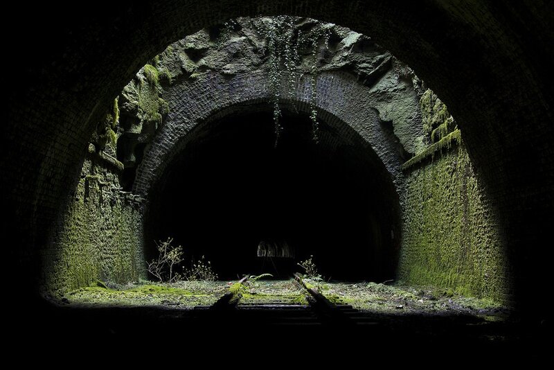 abandoned tunnel with overgrown tracks