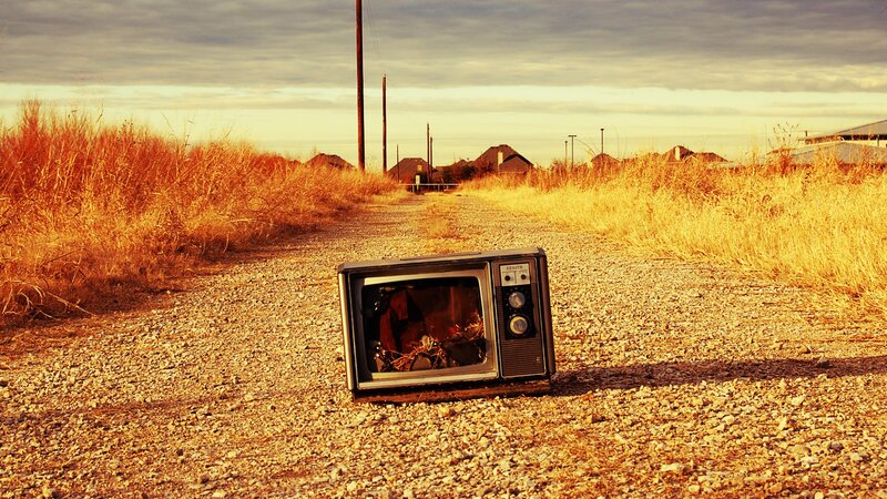 Abandoned TV on a gravel road