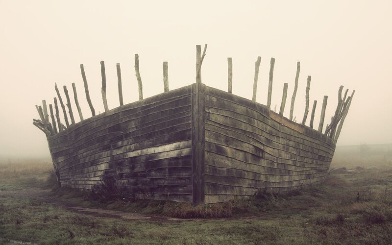 Abandoned wooden boat in fog