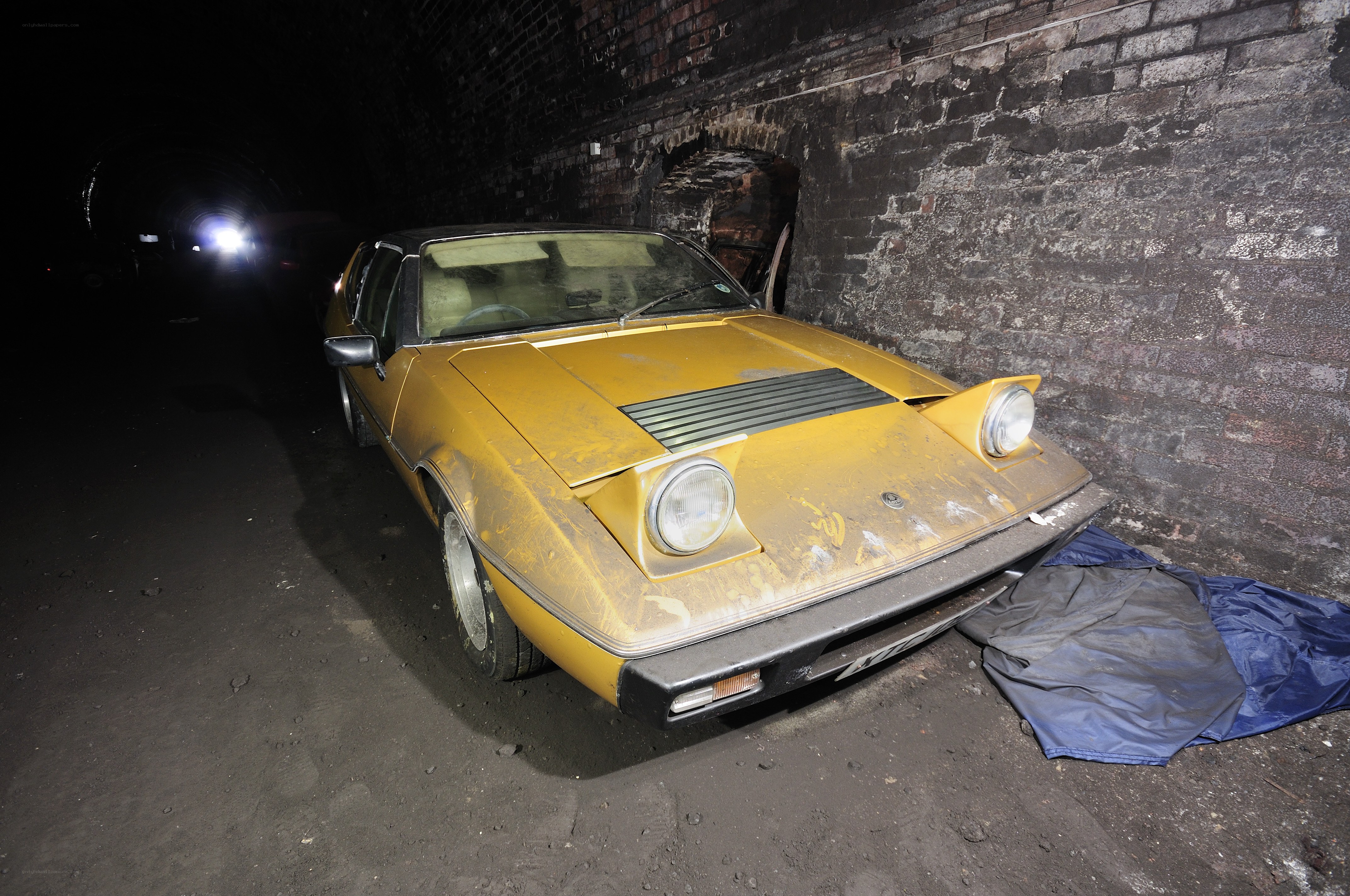 Abandoned yellow car in tunnel