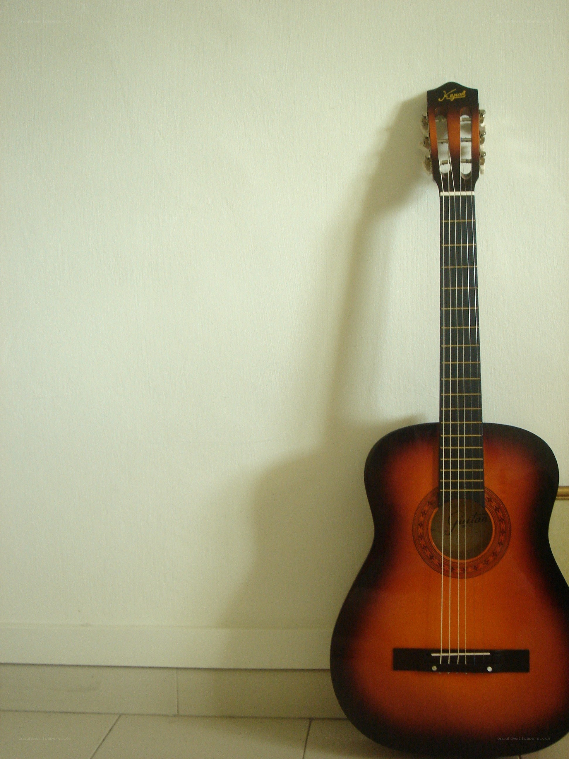 acoustic guitar against wall