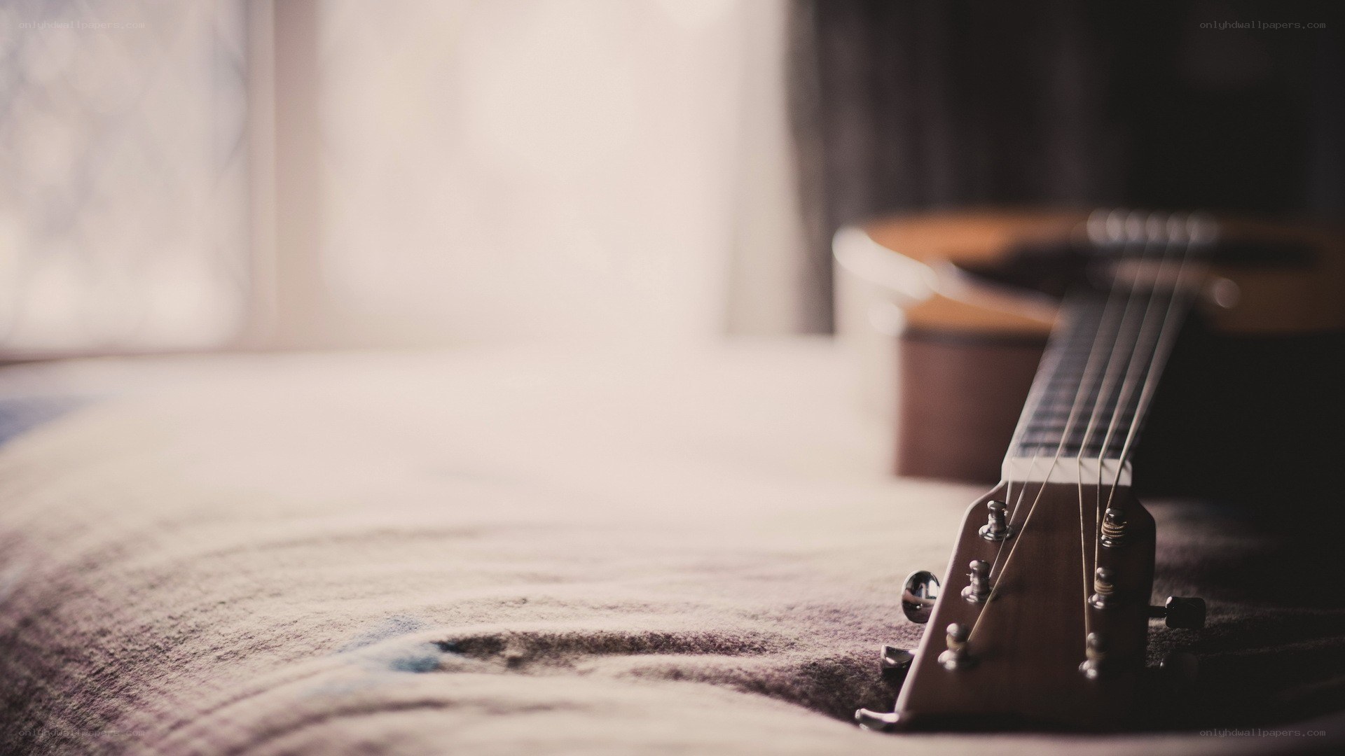 Acoustic guitar on a bed